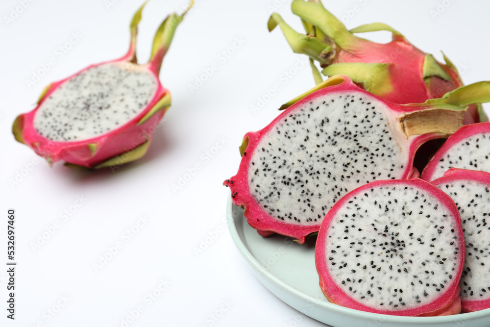 Delicious cut and whole dragon fruits (pitahaya) on white background Delicious cut and whole dragon fruits (pitahaya) on white background