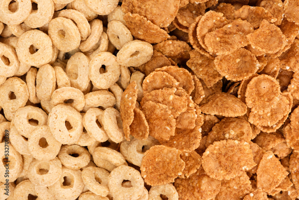 Fototapeta premium Close-up of wheat flakes and corn rings, top view.