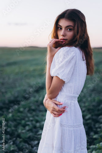 Young girl in white dress in a green meadow. Sensual, pretty, nice woman