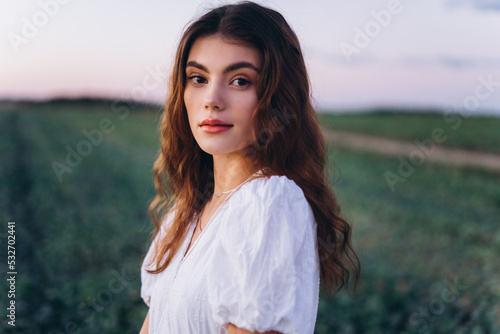 Young girl in white dress in a green meadow. Sensual, pretty, nice woman