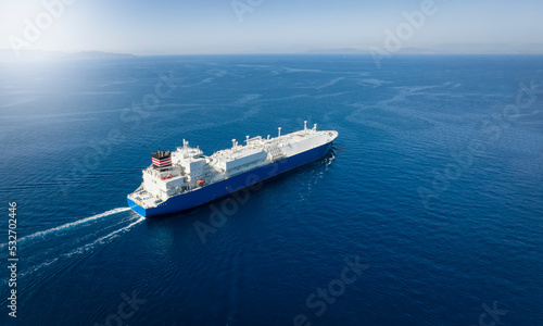 Fototapeta Naklejka Na Ścianę i Meble -  Aerial view of a large LNG or liquid gas tanker ship traveling over blue ocean, with copy space