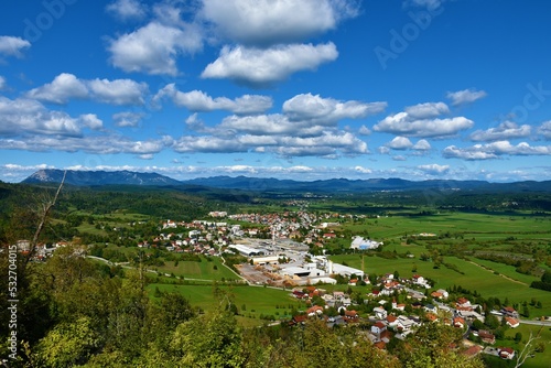 View of the town of Pivka surrounded by fields and forest with Nanos mountain and other hills in Notranjska  Slovenia