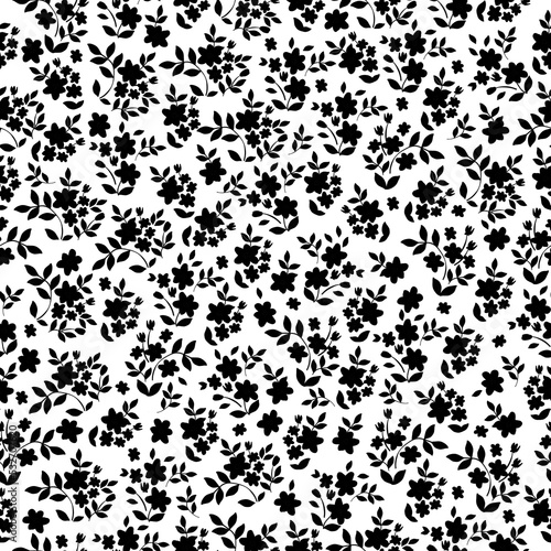 Floral pattern with small black flowers and  leaves on white background. Seamless pattern for design and fashion prints.Stock vector illustration.