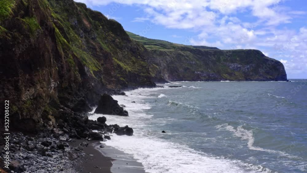 Waves crashing on rugged atlantic cliff coastline of Azores, aerial.