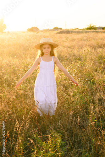 Wallpaper Mural Cute little girl with blond long hair in a summer field at sunset with a white dress with a straw hat Torontodigital.ca