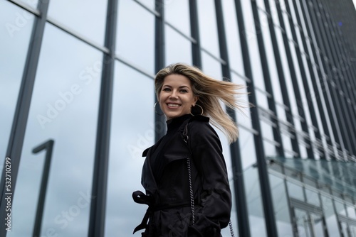 woman Businesswoman with flying hair in the wind against the backdrop of an office building