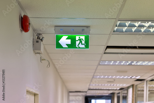 Green emergency exit sign showing the way to escape. Fire exit in the building.	 photo