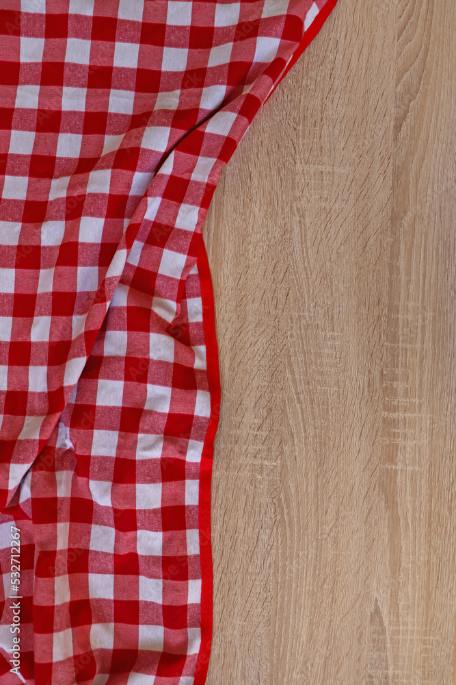 Checkered picnic cloth on wooden table, top view. Space for text Checkered picnic cloth on wooden table, top view. Space for text