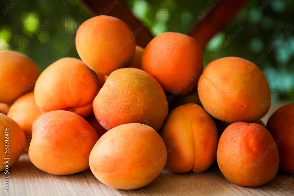 Heap of delicious ripe apricots on wooden table outdoors, closeup Heap of delicious ripe apricots on wooden table outdoors, closeup