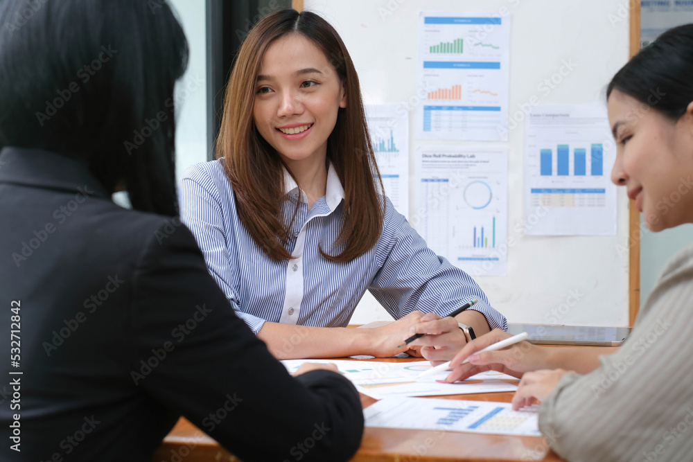 A young asian woman is having a business meeting with her team colleagues in a conference room. A young asian woman is having a business meeting with her team colleagues in a conference room.