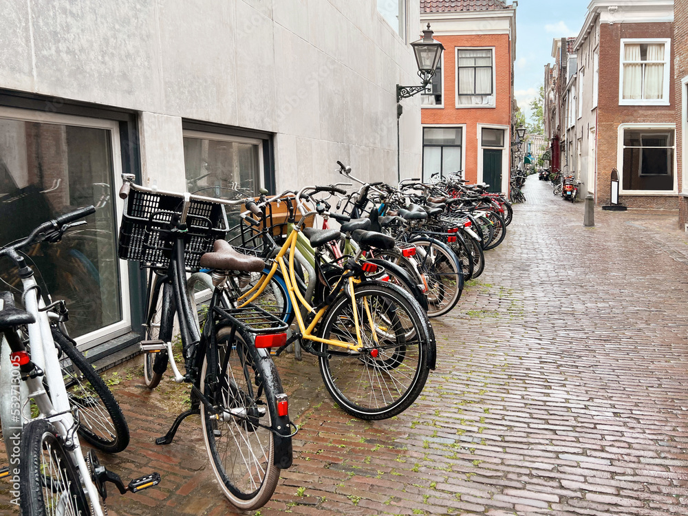 Many parked bicycles near building on city street Many parked bicycles near building on city street