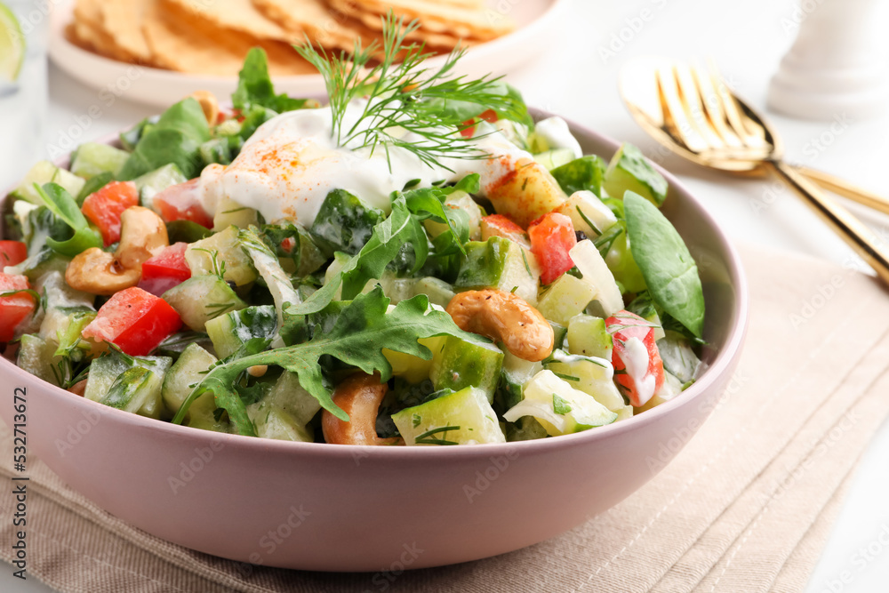 Bowl of delicious cucumber salad served on white table, closeup Bowl of delicious cucumber salad served on white table, closeup