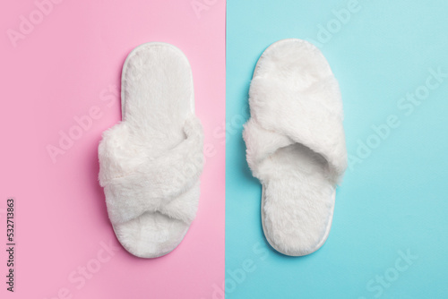 Pair of soft slippers on color background, top view