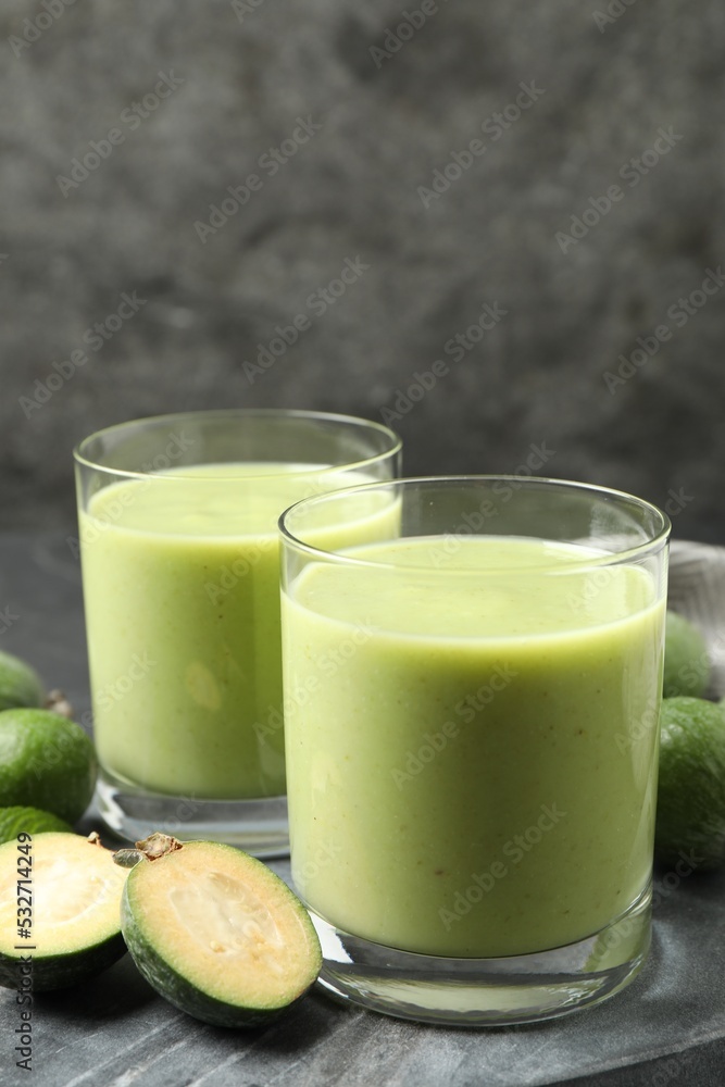 Fresh feijoa smoothie and fresh fruits on grey board, closeup Fresh feijoa smoothie and fresh fruits on grey board, closeup
