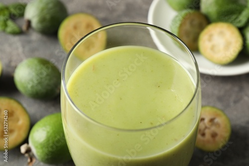 Fresh feijoa smoothie in glass on table, closeup view