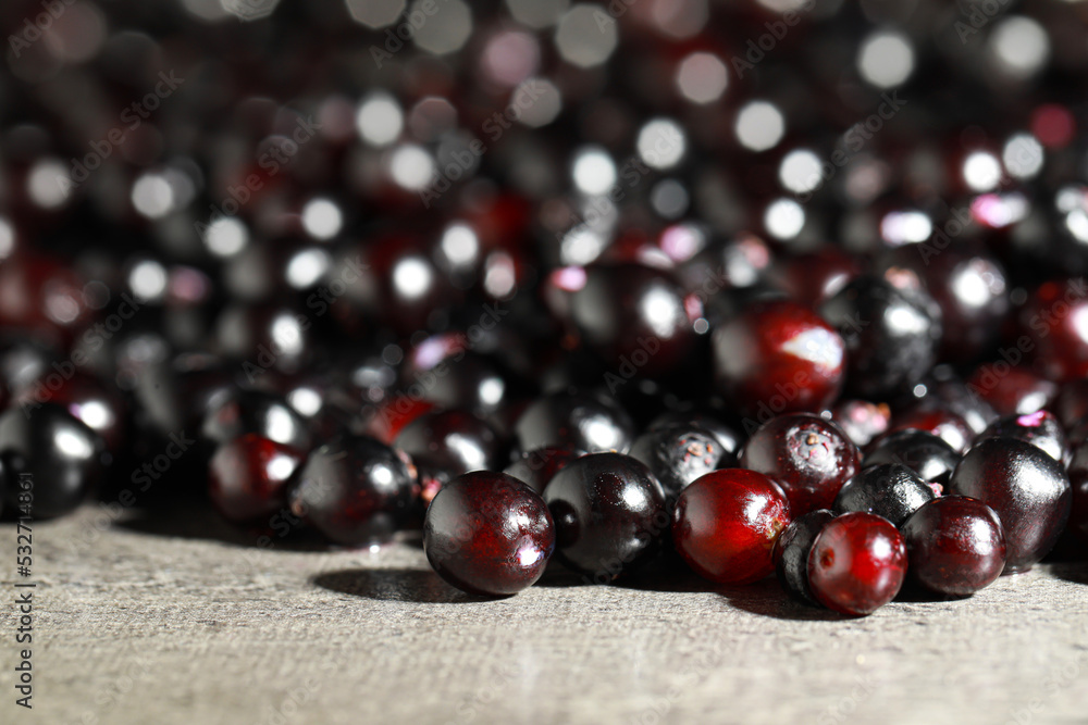 Many black elderberries (Sambucus) on grey table, closeup Many black elderberries (Sambucus) on grey table, closeup
