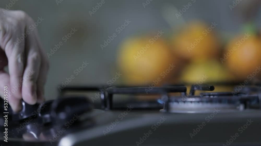 Close up of a man´s hand lighting up a stove burner Close up of a man´s hand lighting up a stove burner