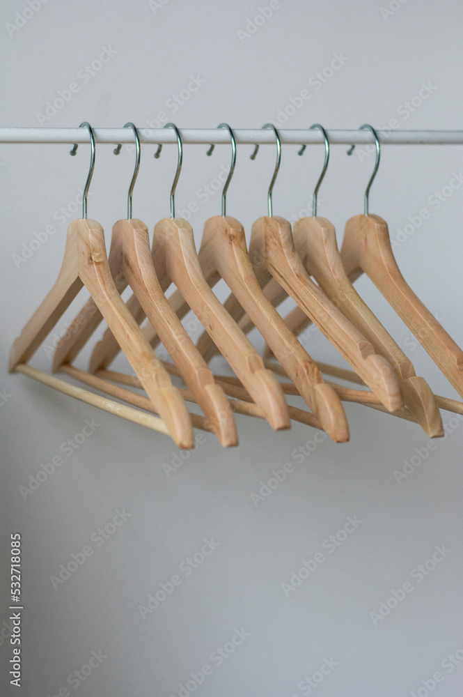 Sustainable fashion concept with wooden clothes hangers. Empty Coathangers In Wardrobe. Concept: wooden hangers recycling zero waste. Storing and Planning a Modern Open Wardrobe Sustainable fashion concept with wooden clothes hangers. Empty Coathangers In Wardrobe. Concept: wooden hangers recycling zero waste. Storing and Planning a Modern Open Wardrobe