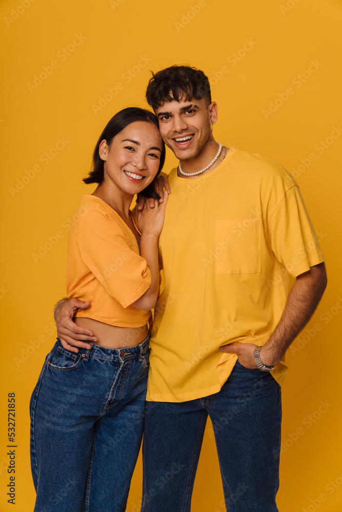 Young multiracial couple hugging while smiling together Young multiracial couple hugging while smiling together