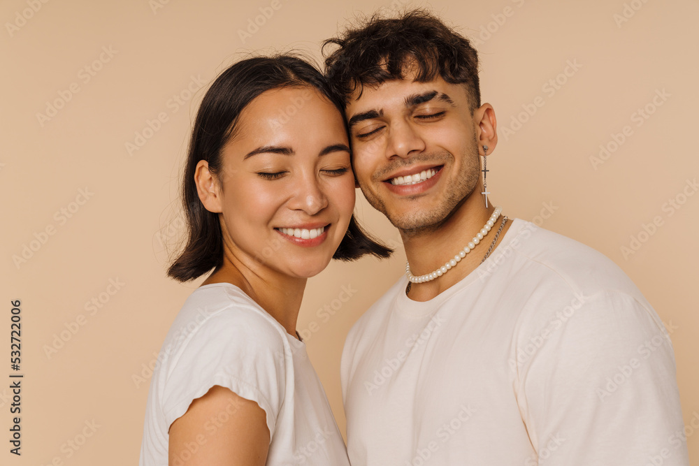 Young multiracial couple posing while smiling together Young multiracial couple posing while smiling together