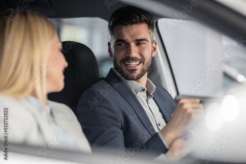 Shot of a cheerful beautiful couple sitting in a car together. Holding hands