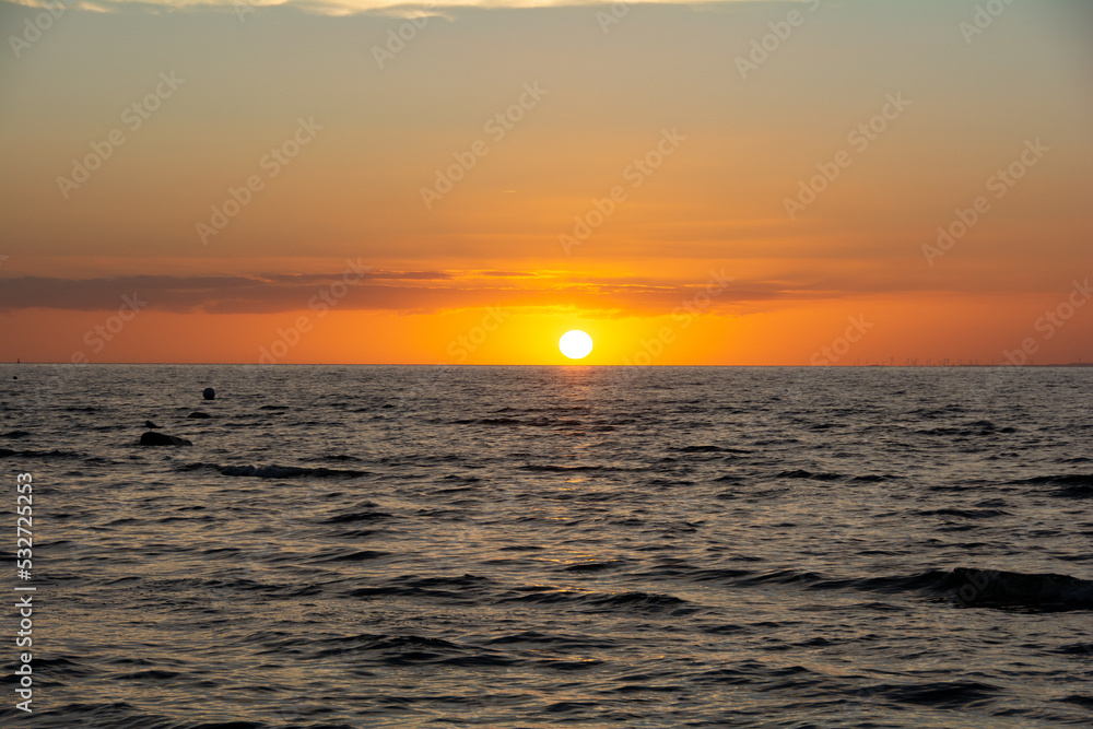 Sun on the horizon, setting over the sea