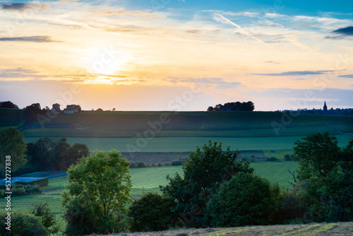 A spectacular and colourful sunset with a dramatic sky over the Jeker valley just outside Maastricht with a view on the Apostelhoeve, the oldest vineyard of the Netherlands during early Autumn