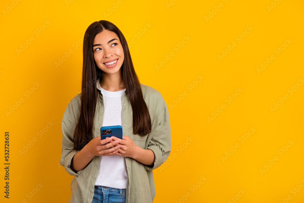 Photo of charming influencer girl look blank space make online shopping purchase isolated on yellow color background Photo of charming influencer girl look blank space make online shopping purchase isolated on yellow color background