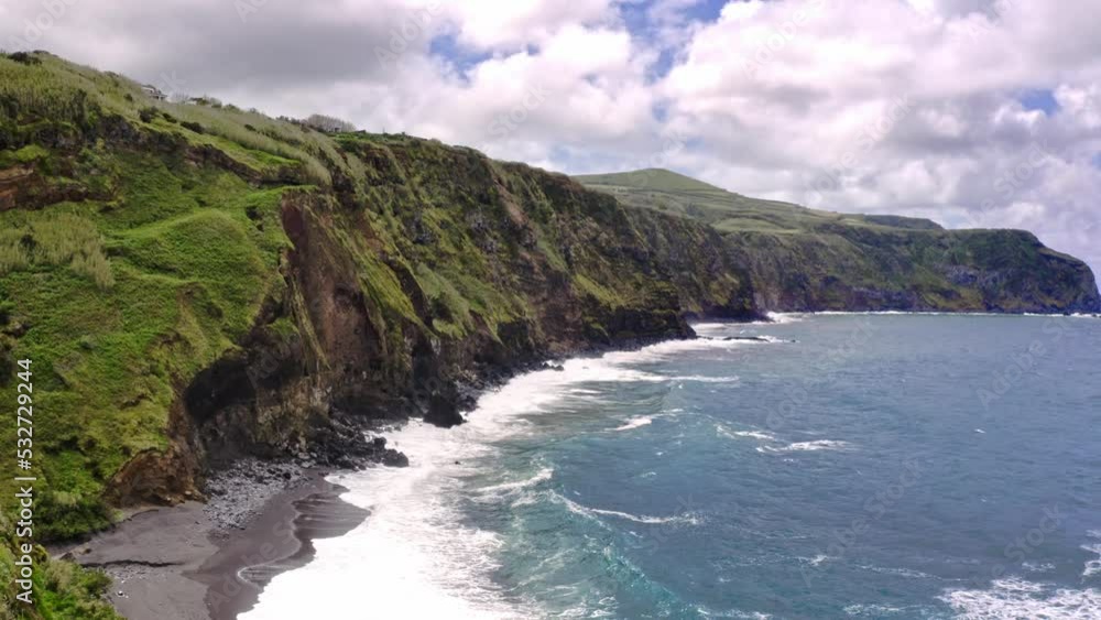 Waves crushing on rugged grassy coastline cliffs, Azores, aerial view. Waves crushing on rugged grassy coastline cliffs, Azores, aerial view.