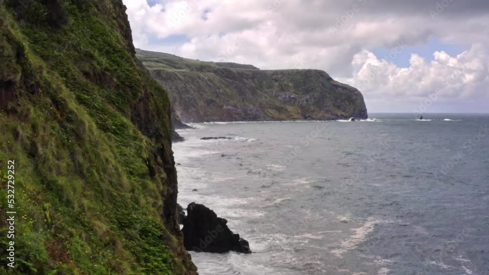 Waves crashing on high rugged coastal cliffs in Azores, flyover shot. Waves crashing on high rugged coastal cliffs in Azores, flyover shot.