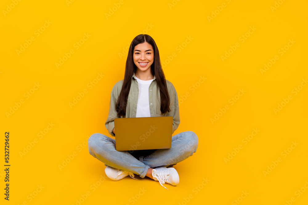Full length photo of charming cheerful person hold wireless laptop toothy smile isolated on yellow color background Full length photo of charming cheerful person hold wireless laptop toothy smile isolated on yellow color background