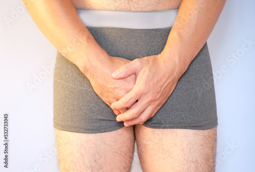 Man suffering from benign prostatic hyperplasia, a urinary tract infection, and polycystic ovary syndrome. Pain and suffering in his genitals are used in the concept of health care. photo