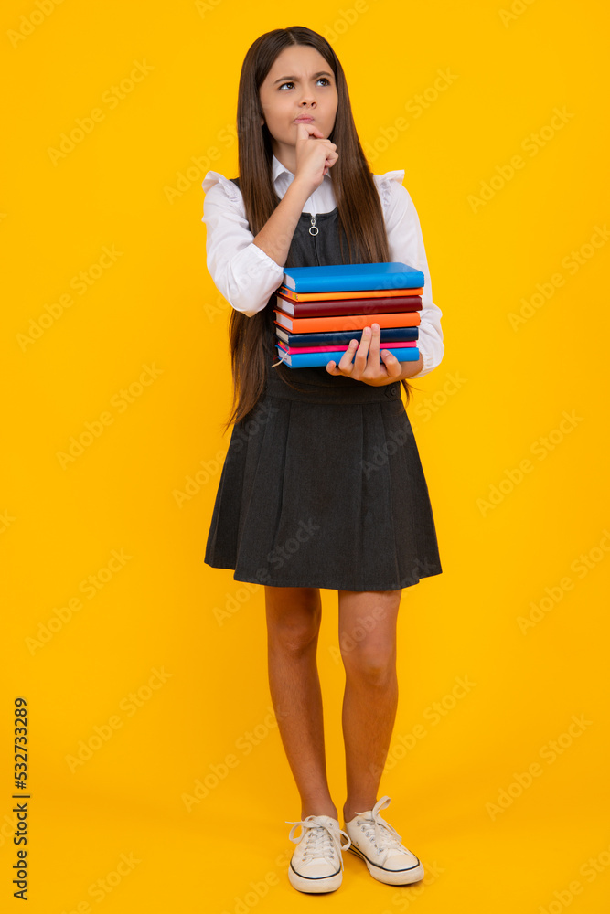 Back to school. Teenager schoolgirl with book ready to learn. School girl children on isolated yellow studio background. Thinking pensive clever teenager girl. Back to school. Teenager schoolgirl with book ready to learn. School girl children on isolated yellow studio background. Thinking pensive clever teenager girl.