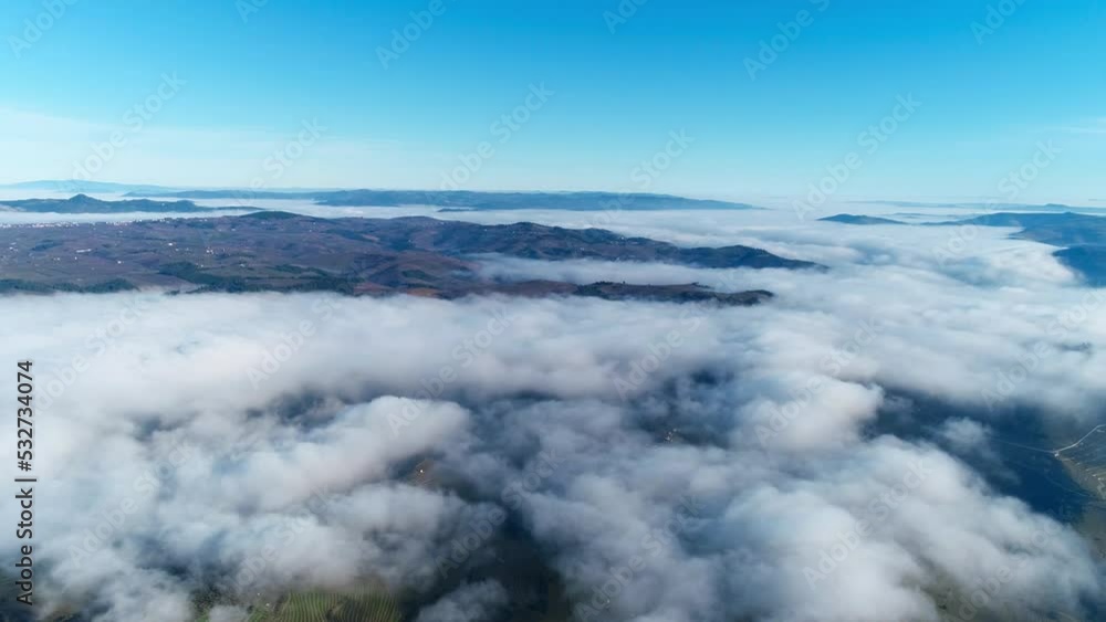 Fly Above Clouds Over Mountains with Blue Sky in the Background. Nature Background. Travel Concept Fly Above Clouds Over Mountains with Blue Sky in the Background. Nature Background. Travel Concept