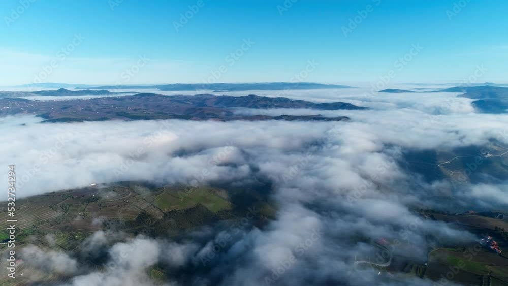 Fly Above Clouds Over Mountains with Blue Sky in the Background. Nature Background. Travel Concept Fly Above Clouds Over Mountains with Blue Sky in the Background. Nature Background. Travel Concept