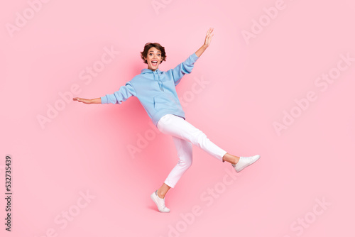 Full body photo of overjoyed lady tendy clothes stand one leg toes good mood imagine can fly empty space isolated on pink color background