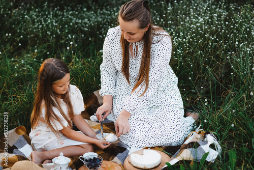 A daughter and mother have a picnic in the garden