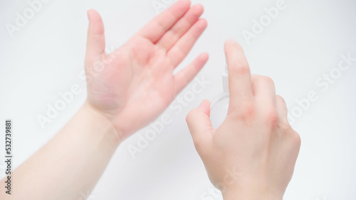 cropped view of man applying hand sanitizer on white background.