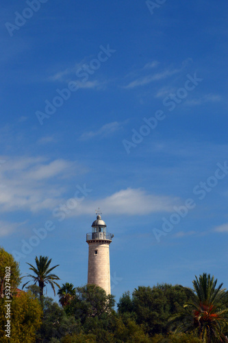 Faro de la playa de Vilanova entre árboles y palmeras
