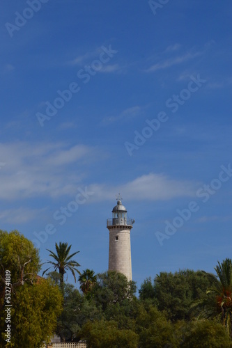 Faro de la playa de Vilanova entre árboles y palmeras