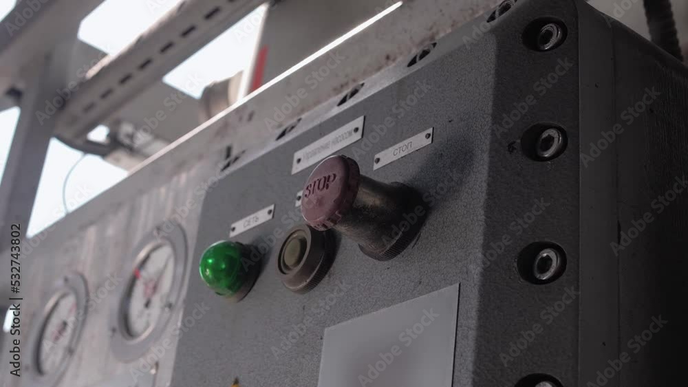 Employee hits the big red button on the electrical control panel at the factory. Close-up Employee hits the big red button on the electrical control panel at the factory. Close-up