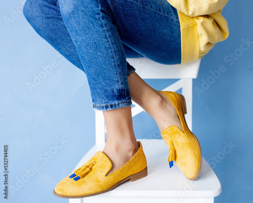 Stylish yellow suede loafers on the girl's feet. Fashionable and stylish shoes and beautiful shoes.