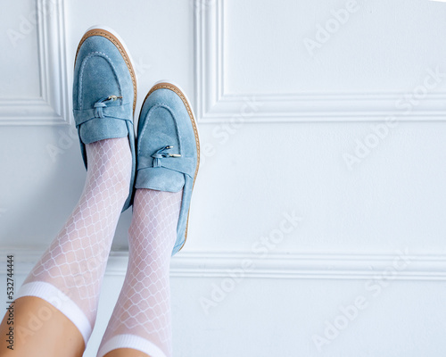 Stylish suede light blue loafers at the girl's feet. Fashionable and stylish shoes and beautiful shoes. photo