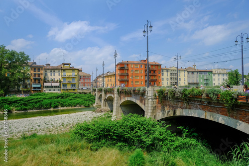 Parma, Italy: bridge Ponte del Mezzo over the river Torrente di Parma across the colorful buildings on a sunny day