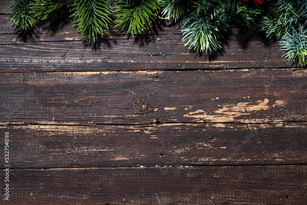 Christmas and New Year greeting card simple background. Spruce branches on dark old rustic wooden table top view copy space Christmas and New Year greeting card simple background. Spruce branches on dark old rustic wooden table top view copy space