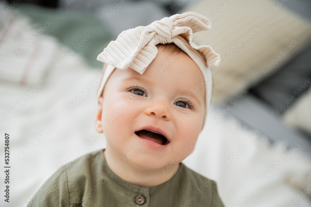 portrait of happy baby girl in pastel pink headband with bow. portrait of happy baby girl in pastel pink headband with bow.