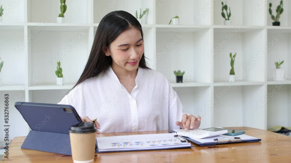 Woman working in finance is doing accounting calculations using a modern calculator and laptop. Woman working in finance is doing accounting calculations using a modern calculator and laptop.