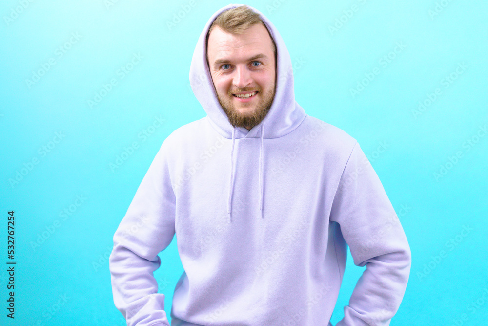 A man in a purple hoodie laughing and looking at the camera on the blue background. Face. Beard. Healthy. Hoodie. Natural. Front. Style. Good. Joyful. Posing. Individuality. Relax. Relaxed. Teeth A man in a purple hoodie laughing and looking at the camera on the blue background. Face. Beard. Healthy. Hoodie. Natural. Front. Style. Good. Joyful. Posing. Individuality. Relax. Relaxed. Teeth