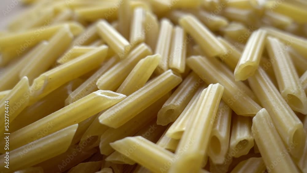 Raw italian penne rigate pasta isolated on wooden background Raw italian penne rigate pasta isolated on wooden background