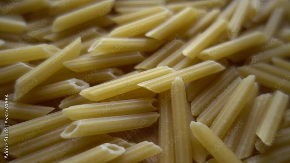Raw italian penne rigate pasta isolated on wooden background Raw italian penne rigate pasta isolated on wooden background